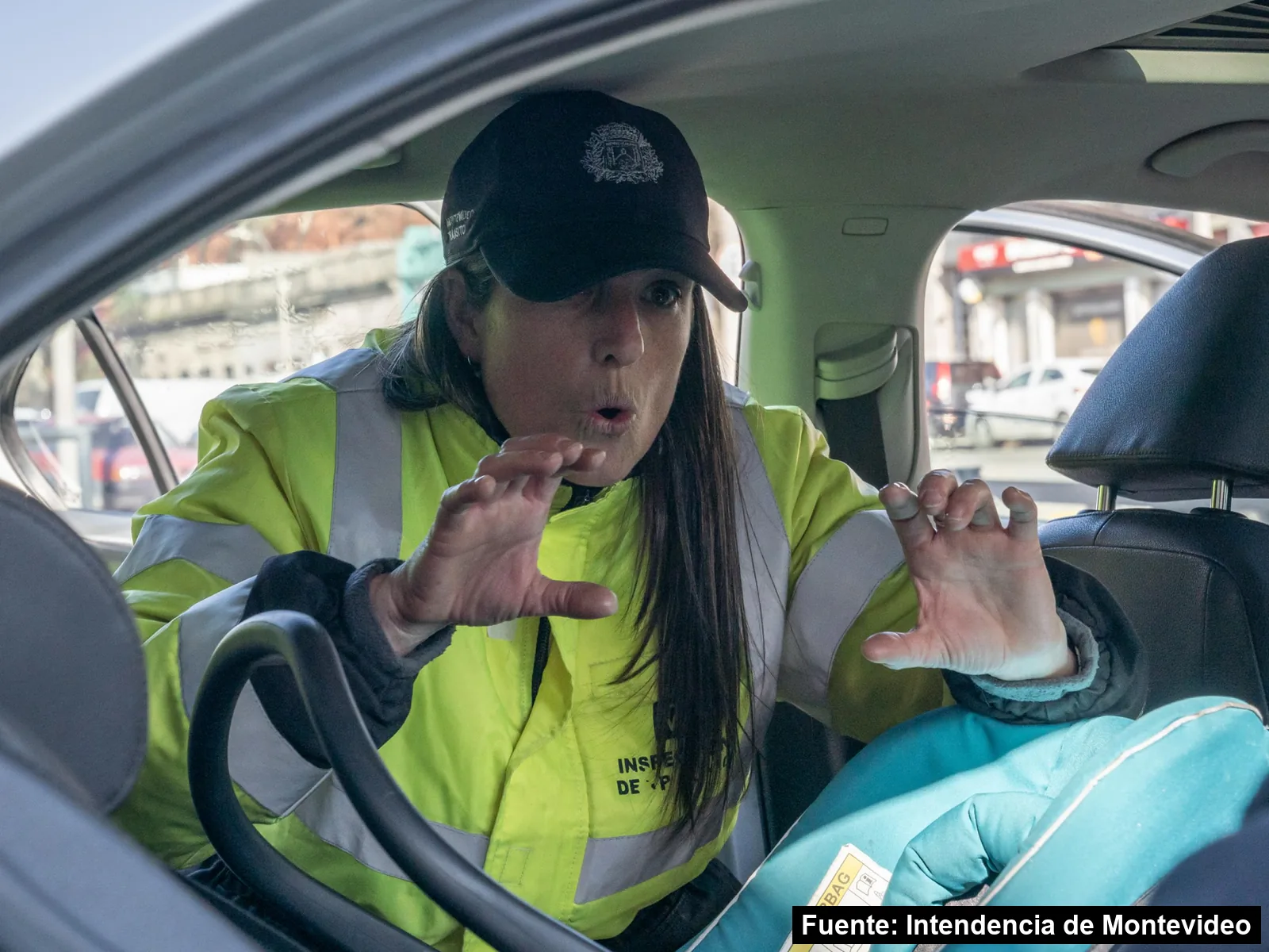 Una inspectora de tránsito de la Intendencia revisa una silla infantil instalada en un auto
