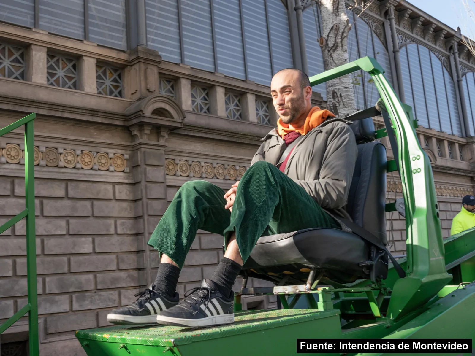 Un hombre prueba el simulador de la Intendencia de Montevideo frente a la fachada del Mercado Agrícola